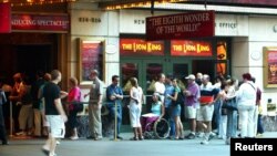 FILE - People wait for tickets outside of the Broadway musical "The Lion King," in New York City.