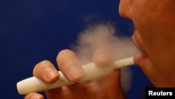 FILE - A man smokes iQOS at a restaurant in Tokyo, Japan, Nov. 2, 2017.