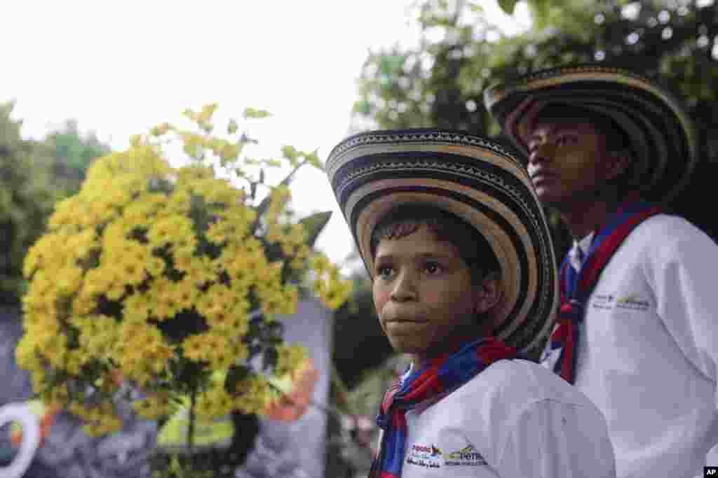 Anak-anak laki-laki dari sebuah kelompok musik menghadiri upacara pemakaman simbolis untuk penulis Gabriel Garcia Marquez di depan gereja di Aracataca, kota di pesisir Karibia tempat Garcia Marquez berasal. (AP/Ricardo Mazalan)