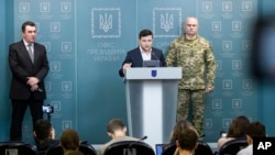 In this handout photo provided by the Ukrainian Presidential Press Office, Ukrainian President Volodymyr Zelenskiy speaks to the media at a briefing following a Security Council meeting in Kyiv, Ukraine, Feb. 18, 2020.