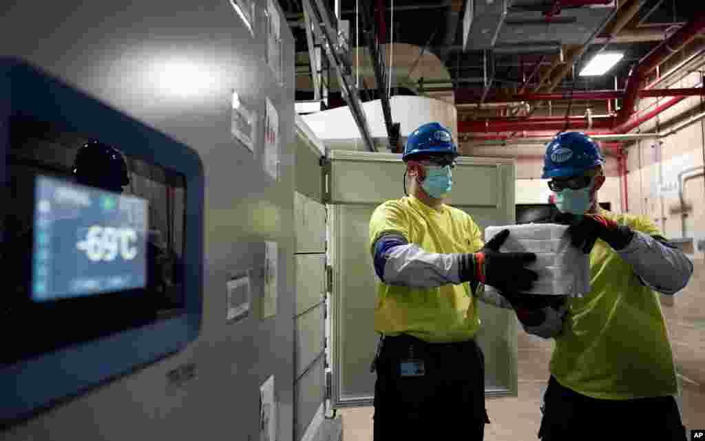The temperature on a freezer reads -69°C as workers move boxes containing the Pfizer-BioNTech COVID-19 vaccines to be shipped at the Pfizer Global Supply Kalamazoo manufacturing plant in Portage, Michigan.