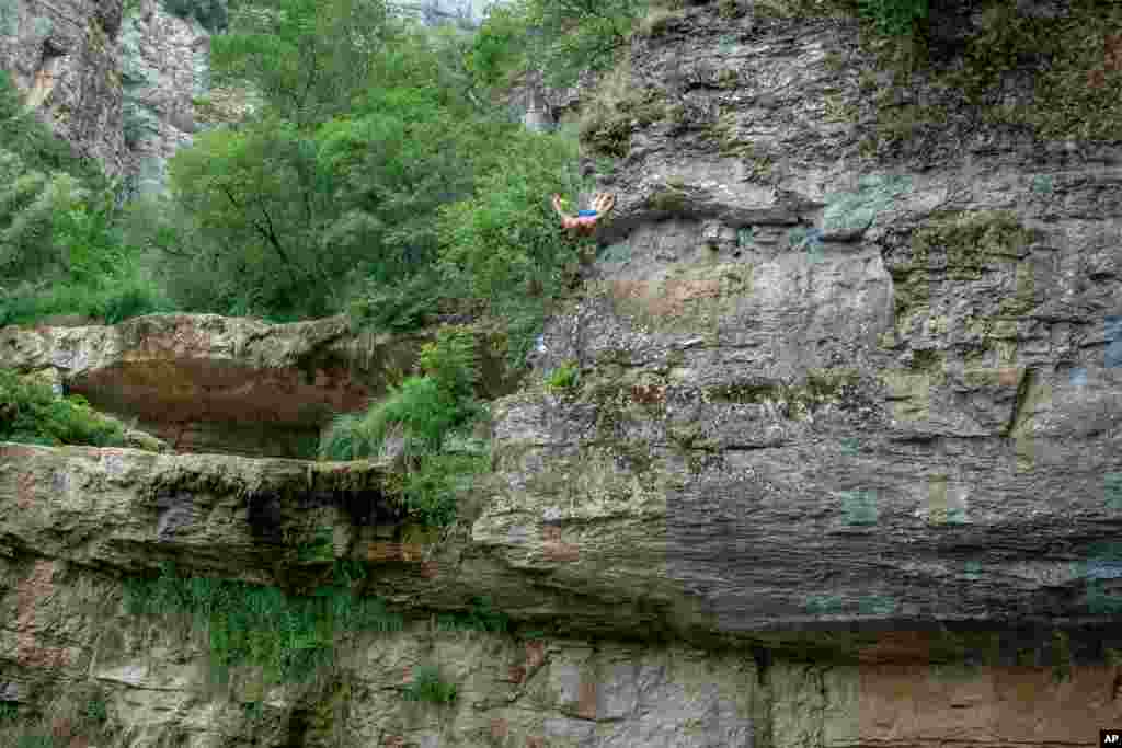 Shkelzen Goqi dives from a 17-meter waterfall during a high diving competition from Mirusha waterfalls near the village Llapceve, Kosovo, July 12, 2020.