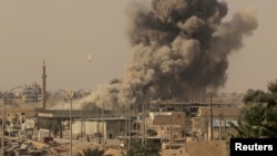 FILE - Smoke rises after an airstrike during fighting between members of the Syrian Democratic Forces and Islamic State militants in Raqqa, Syria, Aug. 15, 2017. U.S. military and intelligence officials say IS's fortunes may be starting to rebound in Syria and Iraq.