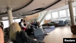 Para penumpang melindungi diri dari atap yang roboh di kapal pesiar Viking Sky saat kapal itu mengalami kerusakan mesin di dekat Hustadvika, Norwegia, 23 Maret 2019, in this still image obtained from a social media video.