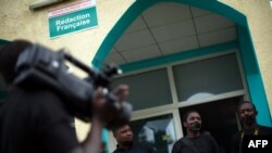 FILE - People with black tape on their mouths attend a press conference of local journalists to mark World Press Freedom Day at the offices of the Iwacu media group in Bujumbura, Burundi, May 3, 2015. 