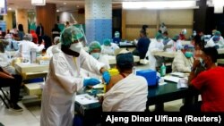 Seorang pedagang menerima dosis vaksin Sinovac Biotech China untuk COVID-19 di Pasar Tanah Abang, 17 Februari 2021. (Foto: REUTERS/Ajeng Dinar Ulfiana)