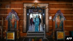 An employee sanitises an area in a Hindu temple in Mumbai on November 15, 2020, as places of worships in Maharashtra state are preparing to reopen after more than eight months of shutdown due to the Covid-19 coronavirus pandemic. 