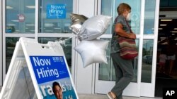 FILE - A shopper passes a hiring sign while entering a retail store in Morton Grove, Ill., July 21, 2021. 