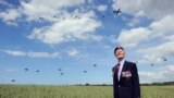 British World War II veteran Frederick Glover looks at soldiers parachuting down during a D-Day commemoration paratroopers launch event in Ranville, northern France, on the eve of the 70th anniversary of the World War II Allied landings in Normandy.