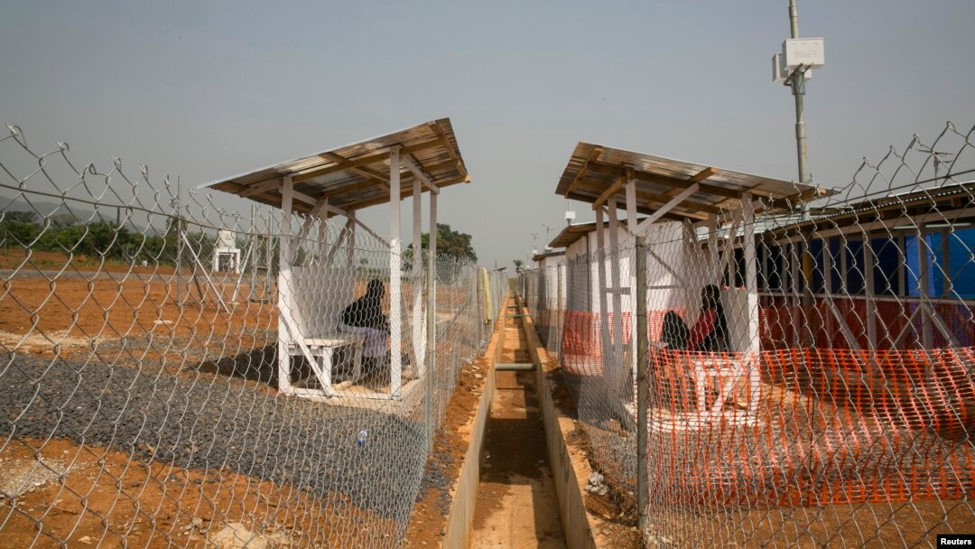 An Ebola patient, who only provided his first name as Peter, right, talks to his wife from within the quarantined zone in the Kerry town Ebola treatment center outside Freetown, Sierra Leone, Dec. 22, 2014. 