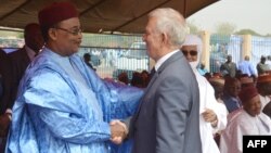 Le président Mahamadou Issoufou du Niger salue Michel Roussin à l'occasion de l'inauguration d'un tronçon ferroviaire de 140 km construit par le groupe français Bolloré et qui reliera à terme Niamey à Cotonou, le 29 janvier 2016.