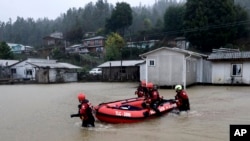 Trabajadores de rescate empujan un bote inflable en el río Pichilo desbordado después de que las tormentas azotaran el área, en la provincia de Arauco, Chile, el jueves 13 de junio de 2024.