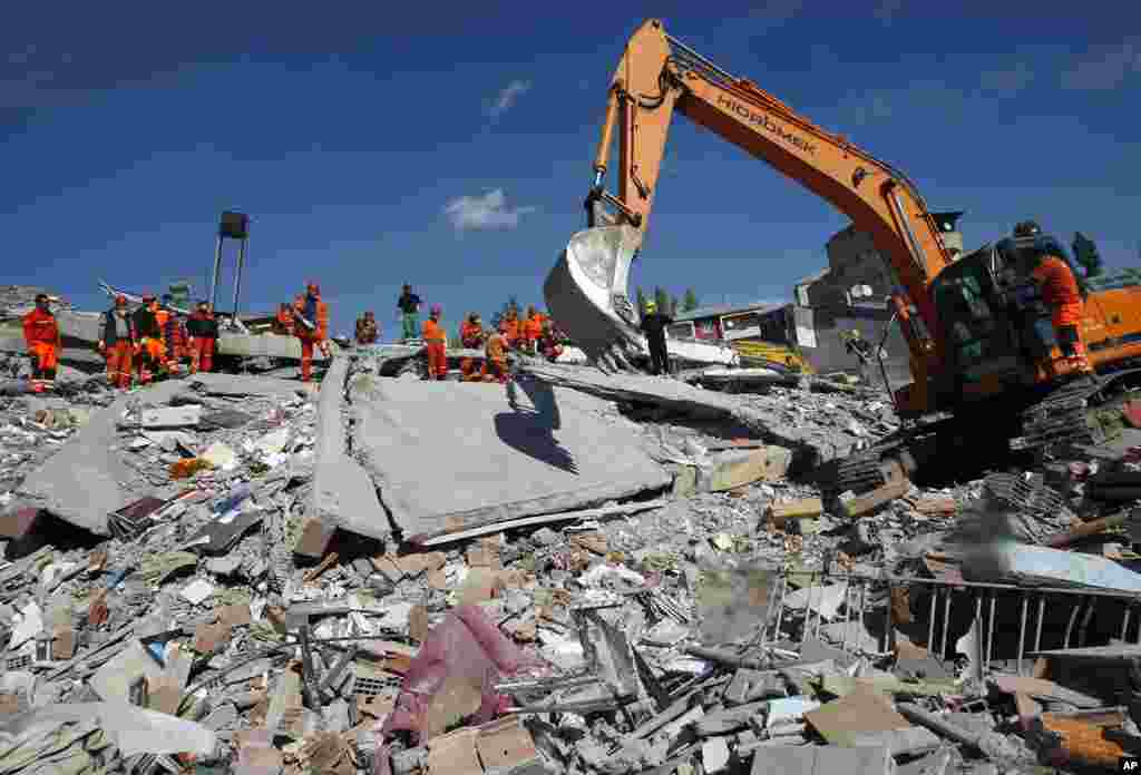 An excavator removes a block of concrete as rescuers work to save people from debris in Ercis, Van, eastern Turkey, October 24, 2011. (AP)