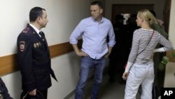 Один из лидеров российской оппозиции Алексей Навальный (в центре) и его супруга Юля разговаривают до начала суда. Москва, Россия. 12 июня 2017 г.