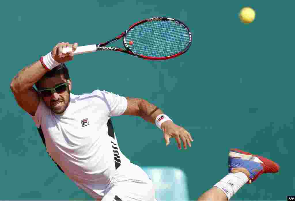 Petenis Serbia Janko Tipsarevic mengembalikan servis dari petenis Bulgaria Grigor Dimitrov pada turnamen ATP di Monte-Carlo, Monaco. 