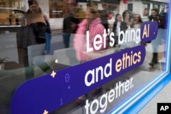 FILE - A window of a building at the Davos Promenade with a slogan about AI alongside the World Economic Forum in Davos, Switzerland, January 18, 2024