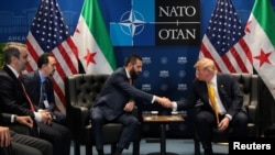 U.S. President Donald Trump shakes hands with Syrian President Ahmed al-Sharaa. July 8, 2026.