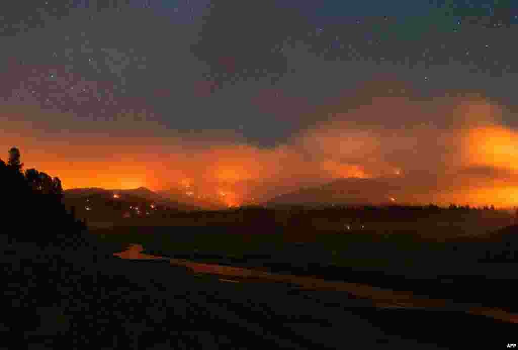 In this long exposure photograph, flames surround a drought-stricken Shasta Lake during the Salt Fire in Lakehead, California, as firefighters battle nearly a dozen wildfires in the region following a heatwave and multiple lightning strikes.