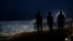 Residents stand on a hill before barriers separating Mexico and the United States, where the border meets the Pacific Ocean, in Tijuana, Mexico, Nov. 17, 2018. Many of nearly 3,000 U.S.-bound Central American migrants have reached the border with California.