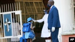 A student has her temperature checked, at the entrance of a private school in Harare, Zimbabwe, Sept. 14, 2020.