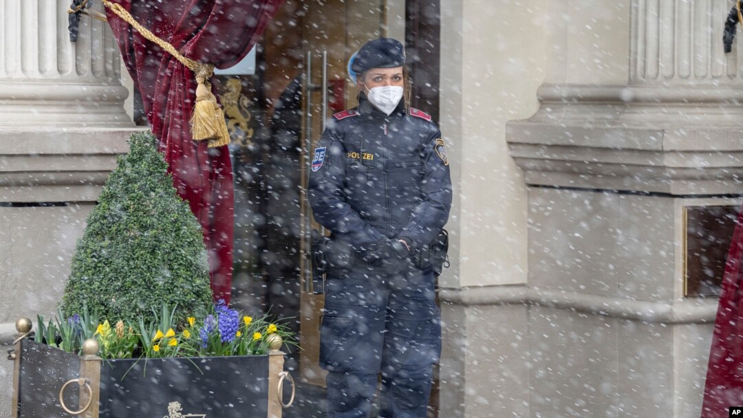 Snow falls as a police officer stands in front of the Grand Hotel Wien where closed-door nuclear talks with Iran take place in Vienna, Austria, April 6, 2021. 