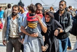 FILE - A man, suspected of having collaborated with the Islamic State group, is greeted by family members upon his release from the Kurdish-run Alaya prison in the northeastern Syrian city of Qamishli, on Oct. 15, 2020.