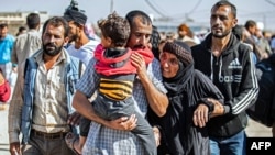 A man, suspected of having collaborated with the Islamic State group, is greetd by family members upon his release from the Kurdish-run Alaya prison in the northeastern Syrian city of Qamishli, on Oct. 15, 2020.