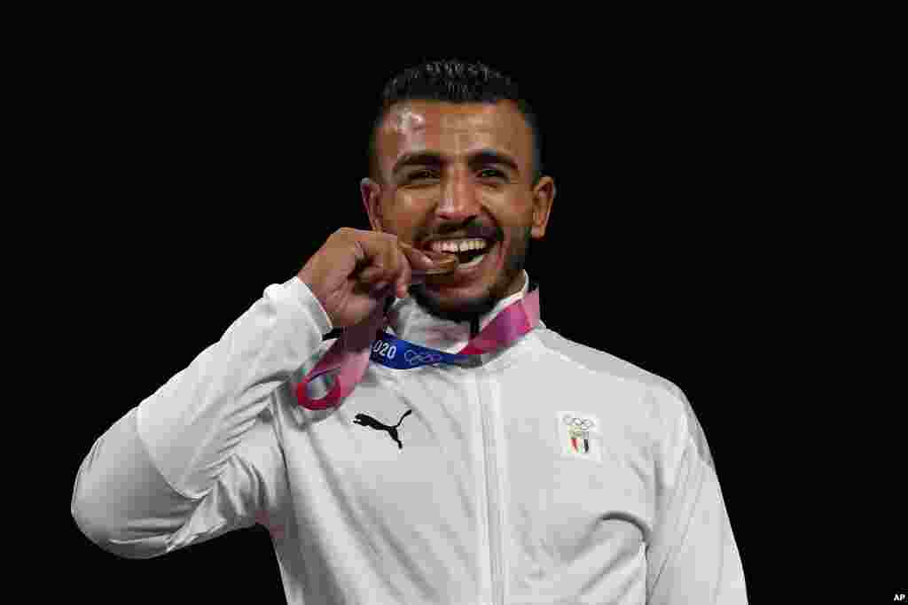 Bronze medalist, Mohamed Ibrahim Elsayed of Egypt celebrates on the podium during the medal ceremony for the men's 67kg Greco-Roman wrestling at the 2020 Summer Olympics, Wednesday, Aug. 4, 2021, in Chiba, Japan. (AP Photo/Aaron Favila)