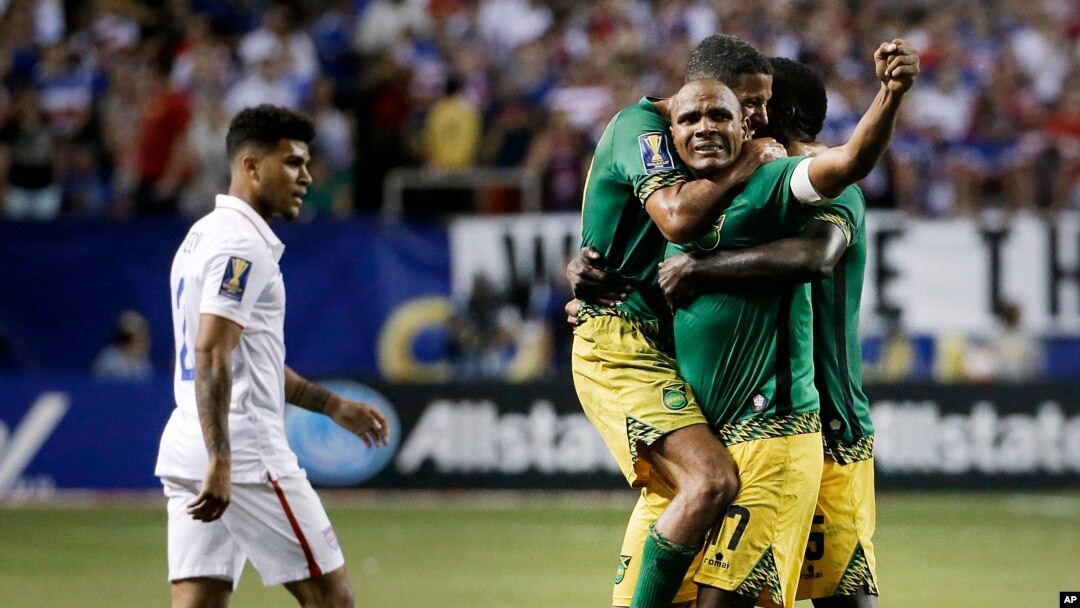 Jamaica’s Rudolph Austin, facing camera, celebrates with teammates Joel McAnuff, left, and Je-Vaughn Watson, right, as United States’ DeAndre Yedlin walks off the pitch after Jamaica defeated the United States 2-1 in a CONCACAF Gold Cup soccer semifinal W