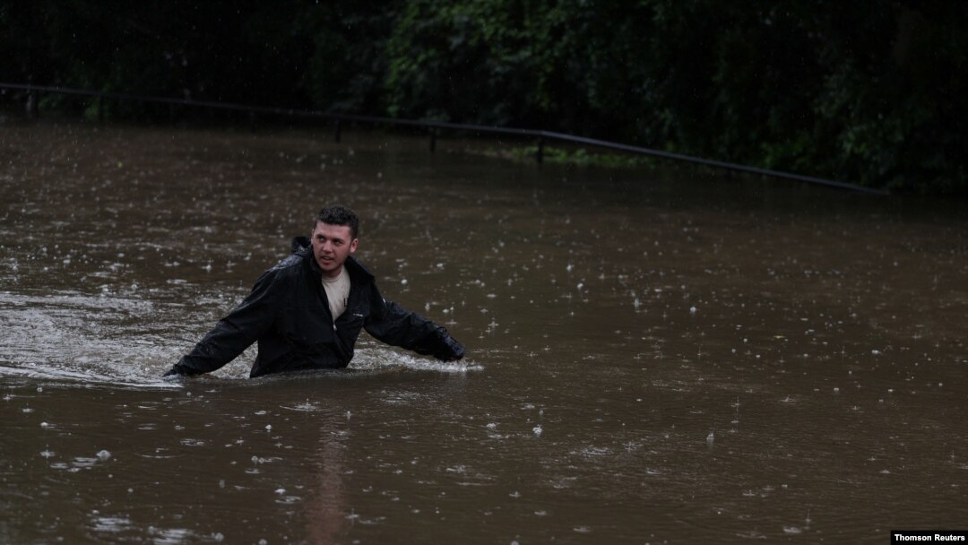 A man wades through floodwaters on a residential street near the swollen Nepean River as the state of New South Wales experiences widespread flooding and severe weather, in Sydney, Australia, March 21, 2021. 