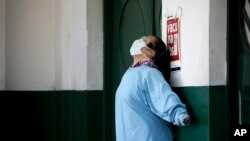 A worker at the Manuel Belgrano public hospital stretches outside the public hospital on the outskirts of Buenos Aires, Argentina, Friday, April 17, 2020.