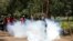 FILE - An anti-corruption protester kicks a tear gas canisters fired by Kenyan police during a protest in Nairobi, Kenya, Apr. 30, 2019. 