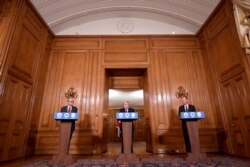 Britain's PM Boris Johnson attends a news conference, together with Chris Whitty, the Chief Medical Officer and Patrick Vallance, UK Gov. Chief Scientific Adviser, in response to the ongoing situation with the coronavirus, London , Dec. 19, 2020.