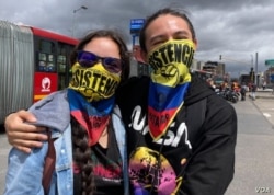 Los manifestantes Michelle Calderón y Diego Parra participan en protestas antigubernamentales en Bogotá, el 20 de julio de 2021.