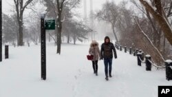 A couple walks along the Mississippi River in downtown Minneapolis, Minnesota, April 14, 2018.