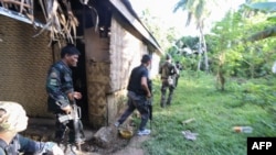 Polisi dan tentara mengambil posisi saat mereka terlibat dengan kelompok Abu Sayyaf di Desa Napo, Kota Inabanga, Provinsi Bohol, di Filipina tengah pada 11 April 2017. (Foto: AFP)