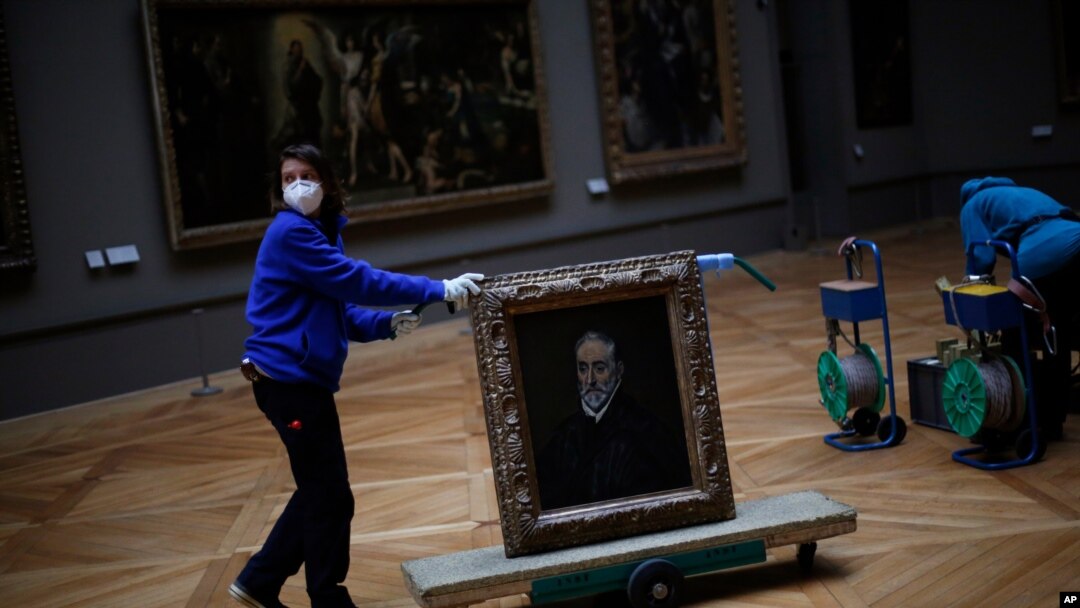 A worker moves the painting "Portrait of Antonio de Covarrubias y Leiva" by Spanish painter El Greco, at the Louvre museum, in Paris, France, Feb. 9, 2021, as the COVID pandemic gives staff a rare opportunity to tackle long-overdue refurbishments. 