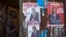A boy enters an house with various campaign posters at the Kangemi slum in Kenya's capital Nairobi, Feb. 28, 2013. 