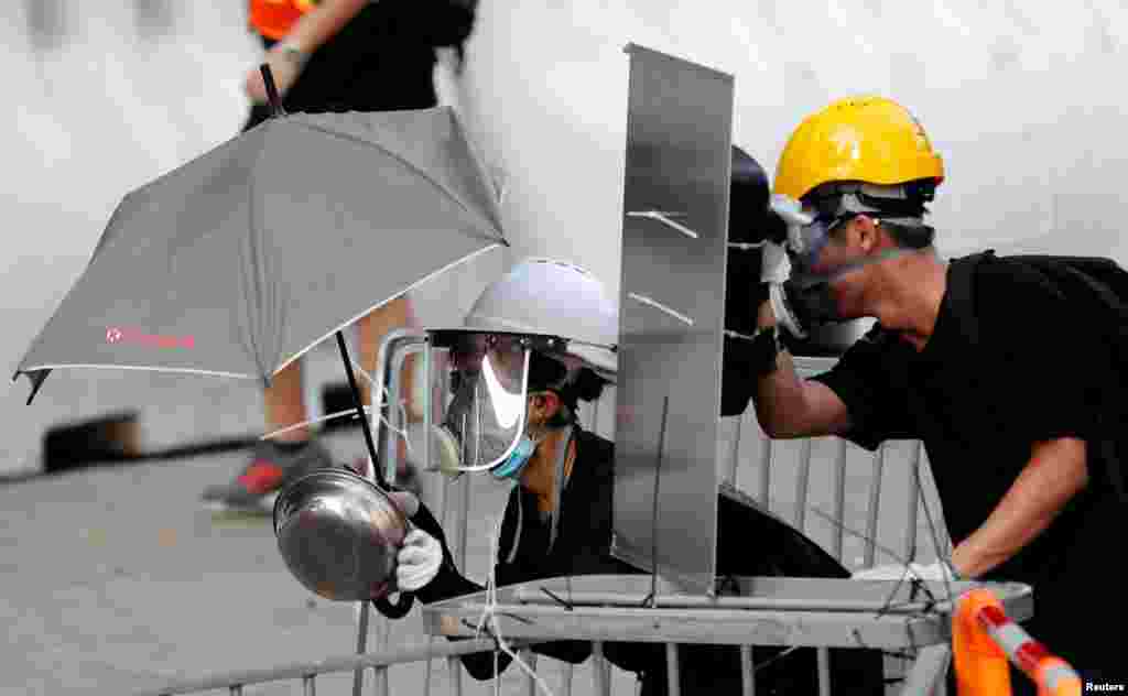 Protesters use makeshift protective gear to avoid tear gas during the city-wide strike to call for democratic reforms outside Central Government Complex in Hong Kong.