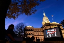 The phrase "Count Every Vote" is projected on a giant screen organized by an advocacy group in front of the State Capitol while election results in several states have yet to be finalized, Friday, Nov. 6, 2020, in Lansing, Mich. (AP Photo/David…