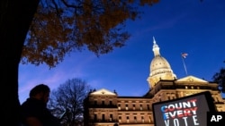 The phrase "Count Every Vote" is projected on a giant screen organized by an advocacy group in front of the State Capitol while election results in several states have yet to be finalized, Friday, Nov. 6, 2020, in Lansing, Mich. (AP Photo/David…