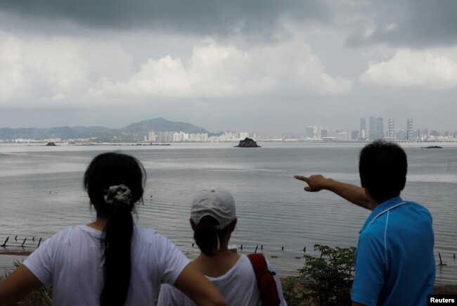 FILE - A tourist points China's Xiamen from a former military fort, ahead of the 60th anniversary of Second Taiwan Straits Crisis against China, on Lieyu island, Kinmen county, Taiwan, Aug. 20, 2018. 