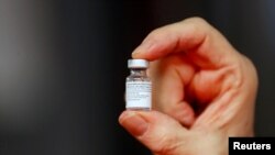 Un trabajador médico sostiene una dosis de la vacuna Pfizer-BioNTech COVID-19. [Foto: Reuters].