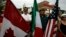FILE - A resident holds the flags of Canada, Mexico and the U.S. 