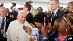 UPope Francis ubonakala lapha ethatha amapikitsha abizwa ngokuthi ngama selfie lozulu eMelika.