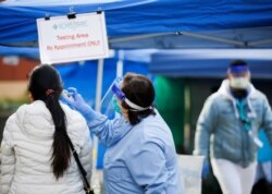 A person gets their temperature checked before entering International Community Health Services in the Chinatown-International District during the coronavirus disease (COVID-19) outbreak in Seattle, Washington, March 26, 2020.
