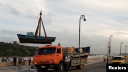 Nelayan di Havana, Kuba, tampak memindahkan kapal mereka menjelang kedatangan badai tropis Rafael ke wilayah tersebut pada 5 November 2024. (Foto: Reuters/Alexandre Meneghini)