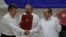 FILE - Colombian President Juan Manuel Santos, left, and Timoleon Jimenez, commander of the Revolutionary Armed Forces of Colombia, or FARC, shake hands during a signing ceremony of a cease-fire and rebel disarmament deal, in Havana, Cuba, June 23, 2016. 