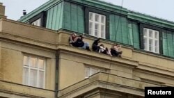 Ljudi gledaju sa krova nakon pucnjave u jednoj od zgrada Karlovog univerziteta u Pragu, Češka Republika, 21. decembra 2023., kao što se vidi na ovom snimku ekrana preuzetom sa video snimka na društvenim mrežama. Ivo Havranek/preko REUTERS-a