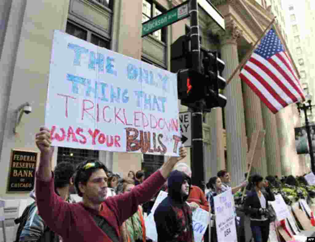 Rafael Franco, from Puerto Rico, holds up a sign on the corner of LaSalle and Jackson during an Occupy Chicago protest Monday, Oct. 3, 2011, in Chicago. "Occupy Chicago" protests started Monday near the Federal Reserve Bank and Chicago Board of Trade, as